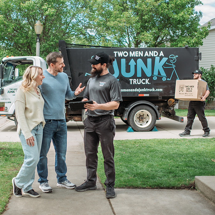 junk haulers speaking to customers and answering questions about how junk removal services work