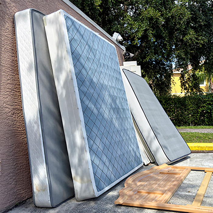 old mattress sitting outside that needs mattress disposal haul away service from a junk removal company