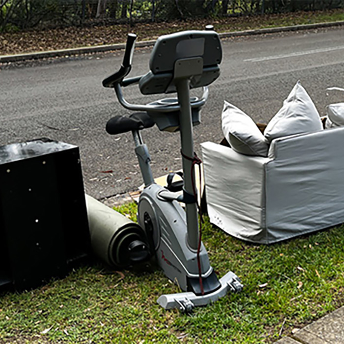 old exercise bike sitting on outside waiting for the junk removal company to haul away