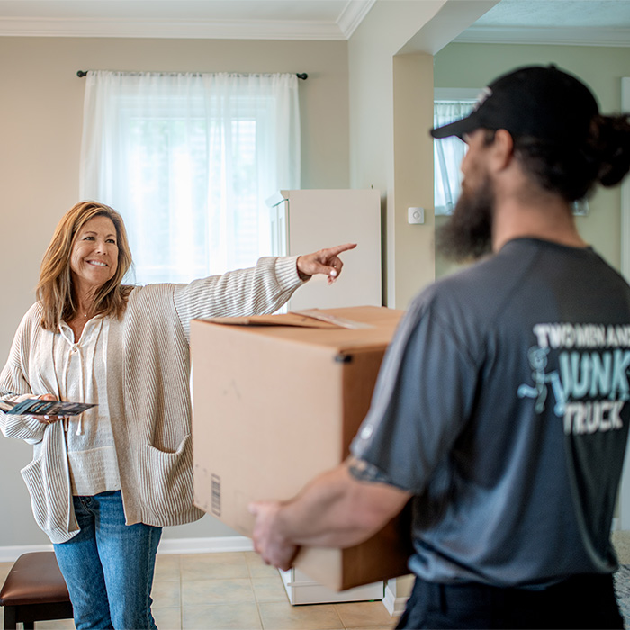 customer giving directions to junk haulers within her home