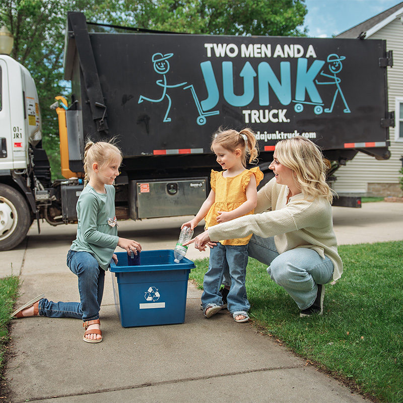 family in front of home practicing land fill diversion through recycling