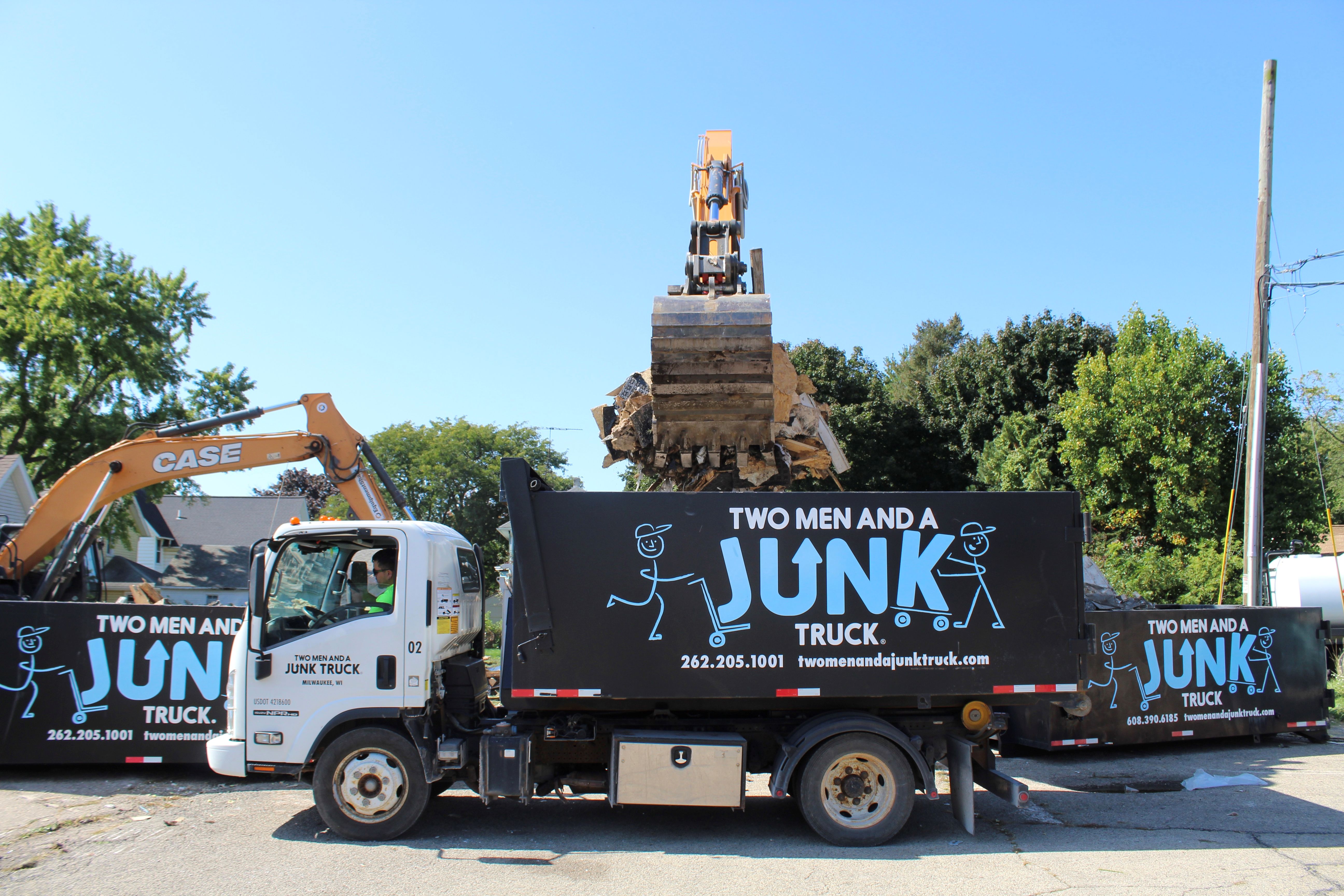Backhoe Dumping Debris into Junk Truck