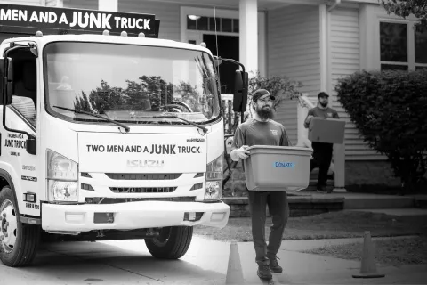 junk hauler leaving customer home with donation box