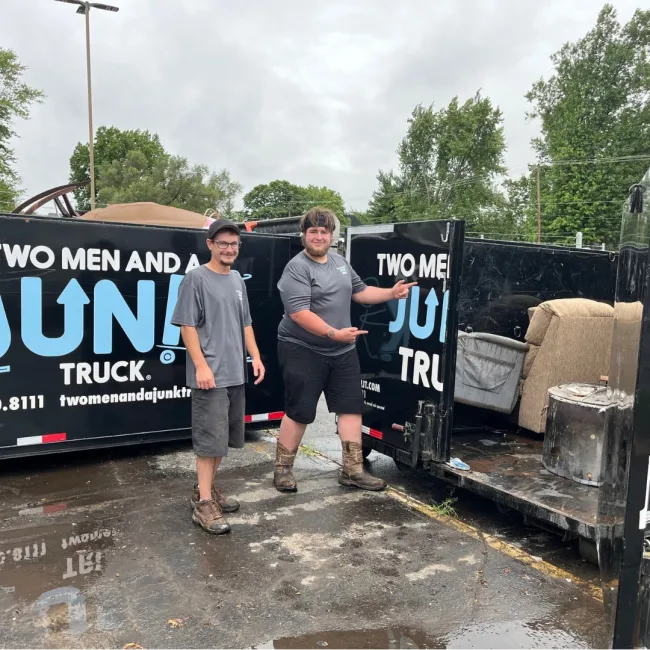TMJT Haulers loading up an old couch, ottoman, and trash can