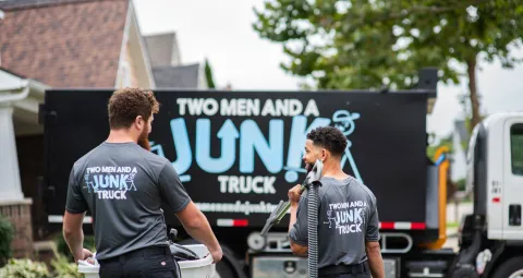 Junk specialists walking toward junk removal truck