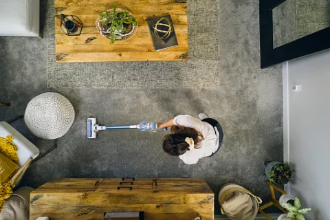 A woman vacuuming her living room after everything has been organized