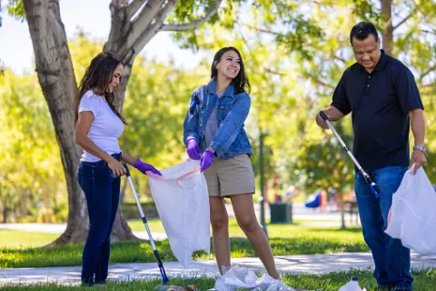 Men and women picking up trash in their local park