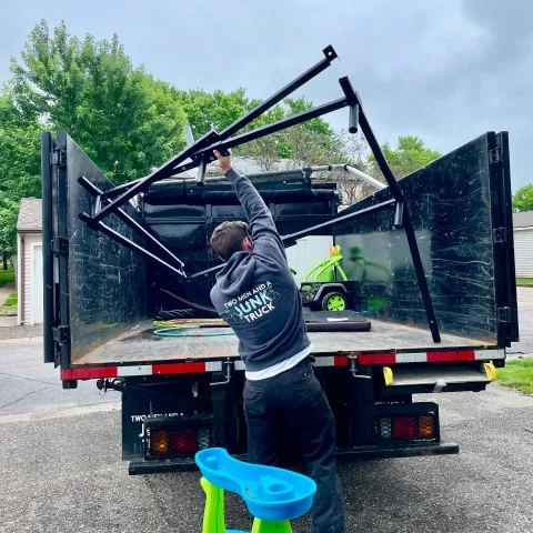 Hauler putting scrap metal into the back of a truck