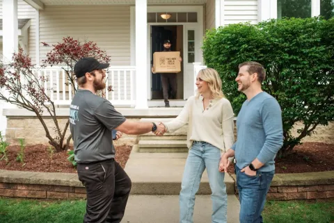 customers standing outside their home are pleased with the help of the junk haulers decluttering their home