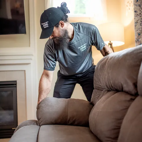 junk hauler performing couch removal services in a customer home