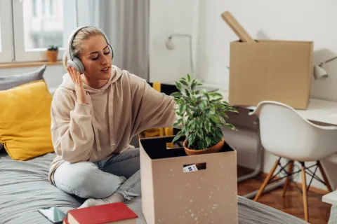 College student listening to music while packing
