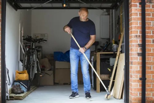 A man sweeping out his garage