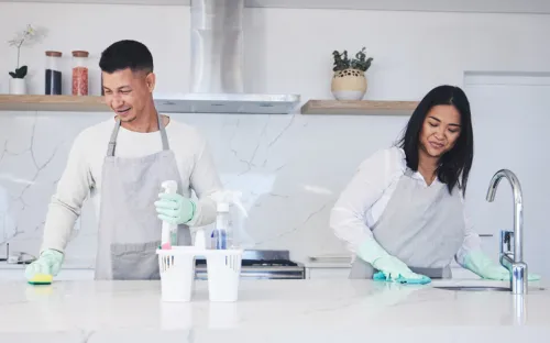 A couple deep cleaning their kitchen