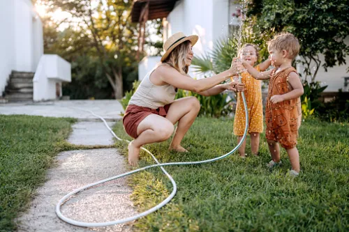 A mother playing with her kids by the side of her house with no clutter or chaos in sight!