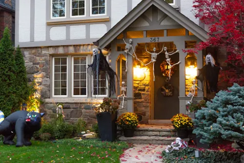 A front porch with inflatable Halloween decor and hanging decorations all over