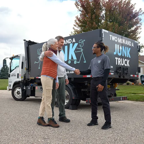junk hauler is shaking the hands of happy customers who are pleased with their junk removal services