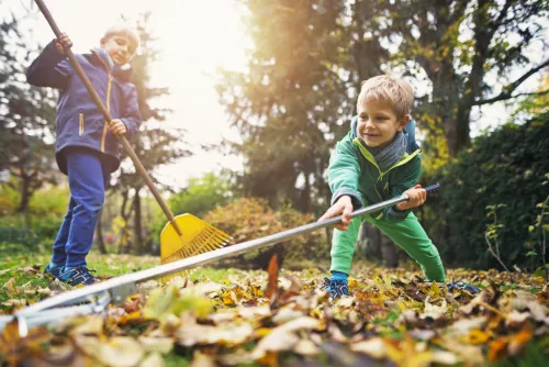 kids playing in the yard helping with fall cleanup