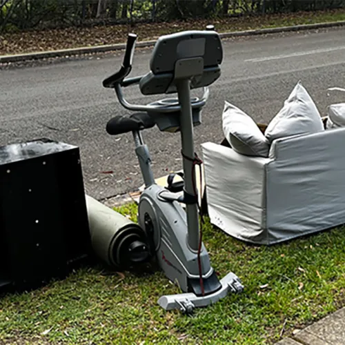 old exercise bike sitting on outside waiting for the junk removal company to haul away