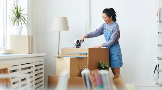 A young woman packs up her college dorm and prepares to move out
