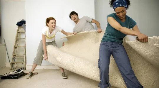 Friends ripping away an old carpet