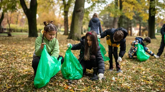 A group of kids picking up leaves in their community
