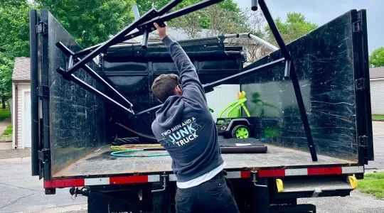 Hauler putting scrap metal into the back of a truck