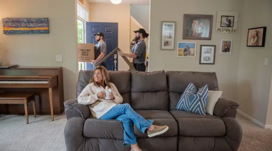 customer sitting on couch while junk haulers perform fall decluttering cleanout services