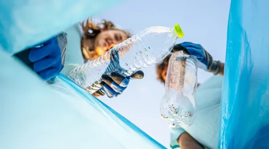two people recycling plastic bottles on americas recycle day