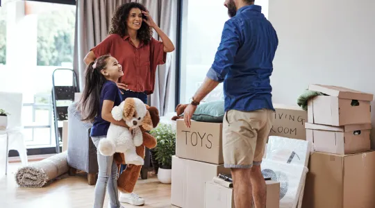 A mom, dad, and young daughter packing to move