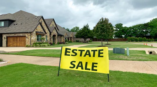 Home with "Estate Sale" sign in the front yard