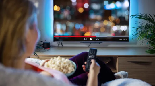 a woman watching a new flat screen tv after disposing of her old tv