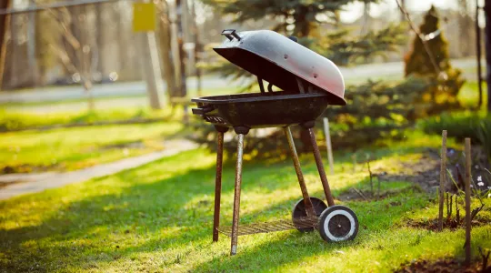 An old grill that is taking up space in a backyard and giving a negative image to the outdoor space