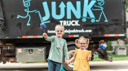 children-celebrating-july-4th-in-front-of-junk-truck