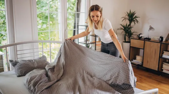 woman-folding-blankets-to-keep-home-clean-and-decluttered